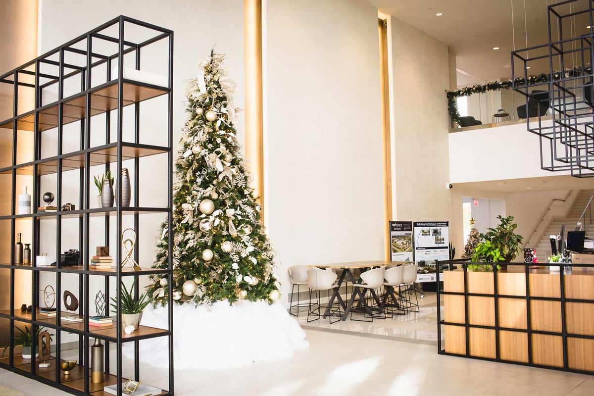 White and Ivory christmas tree with snow blanket in a multitenant office space