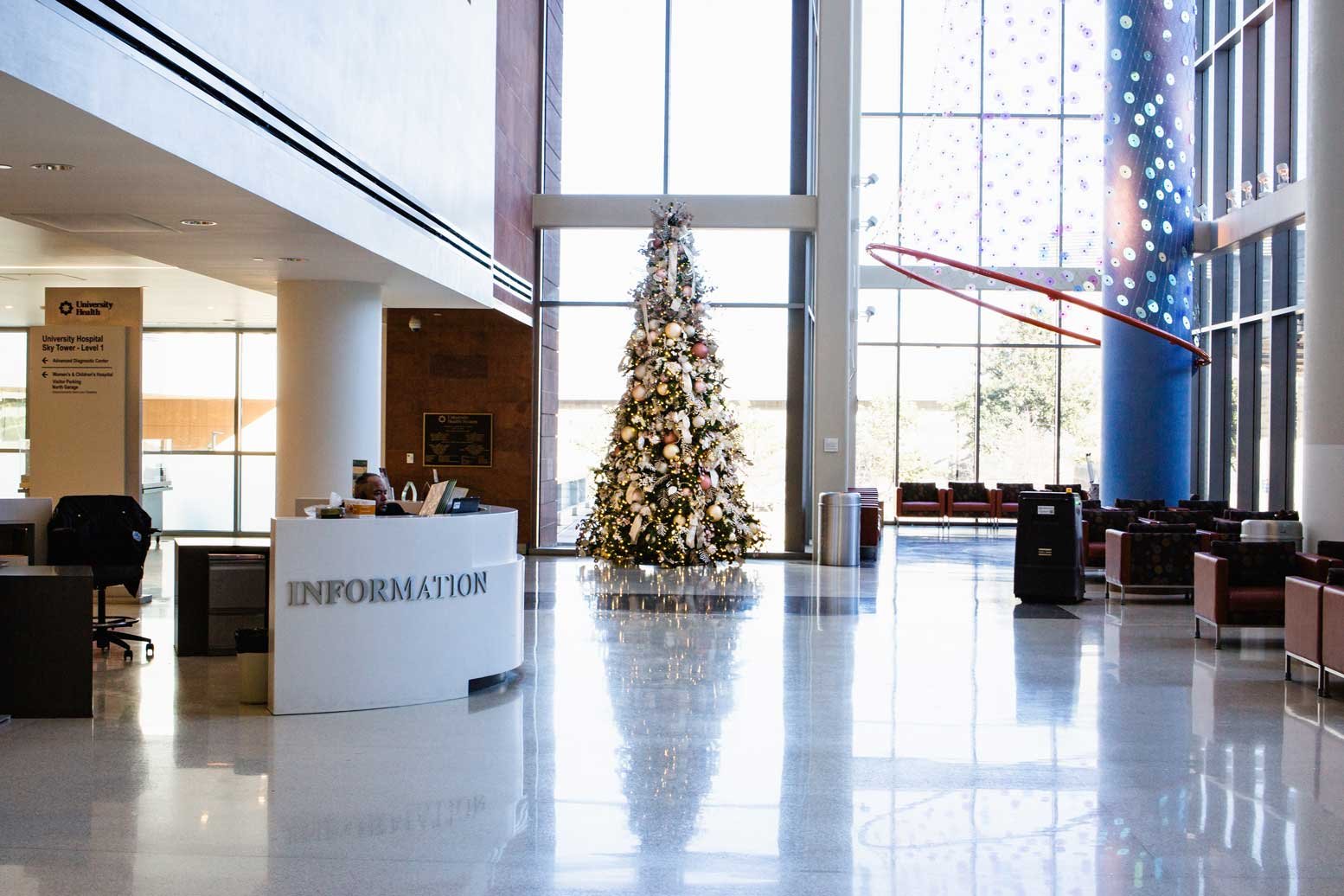 White, Ivory, and Orange Christmas tree in a hospital lobby