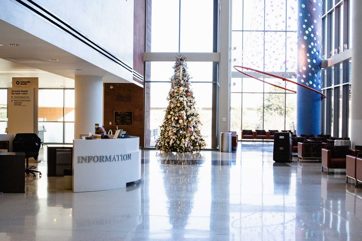 White, Ivory, and Orange Christmas tree in a hospital lobby