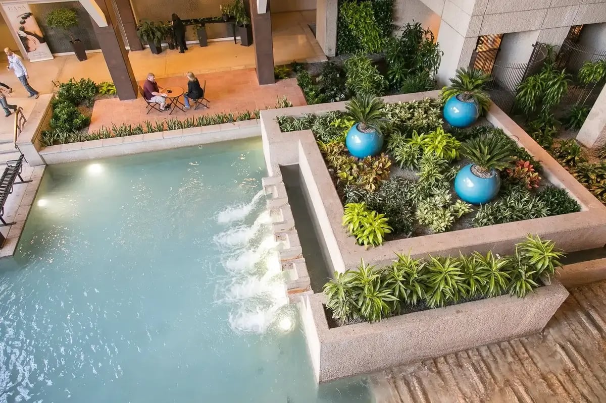 Interior hotel space with potted plants and water features