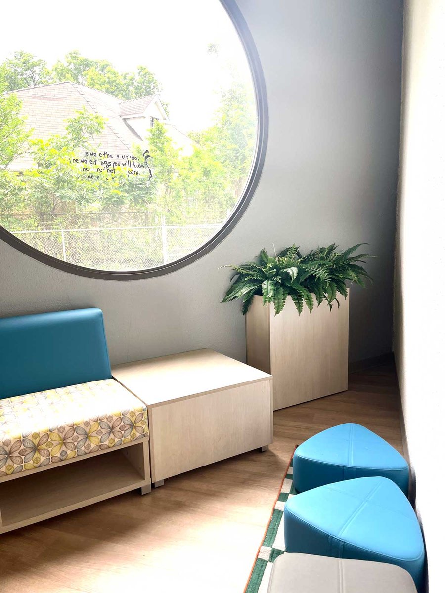 Clinic waiting area with a plant in a wooden plant holder 