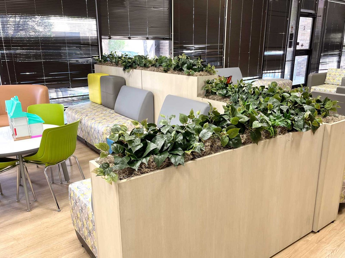 Clinic waiting room with built-in planters filled with replica / faux Pothos Ivy 