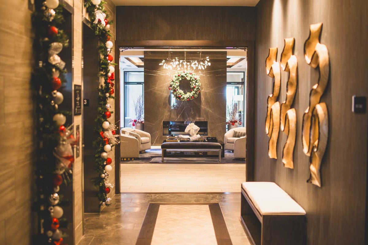 7600 Broadway: lobby area with red and white holiday decor featuring garland and wreaths