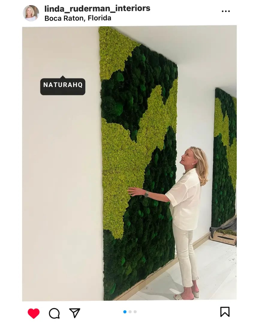 Lady standing in front of a moss wall