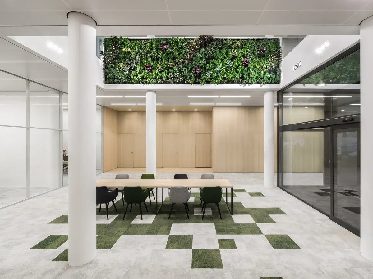 grass on the floor between tiles and on the top of the wall is a living green wall